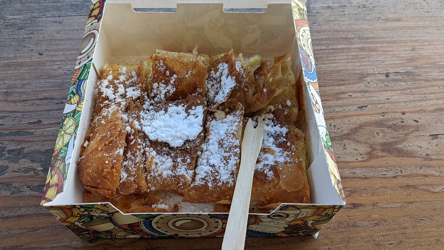 Frische Bougatsa mit Puderzucker in einer Schachtel aus einer Bäckerei in Kallithea, Athen